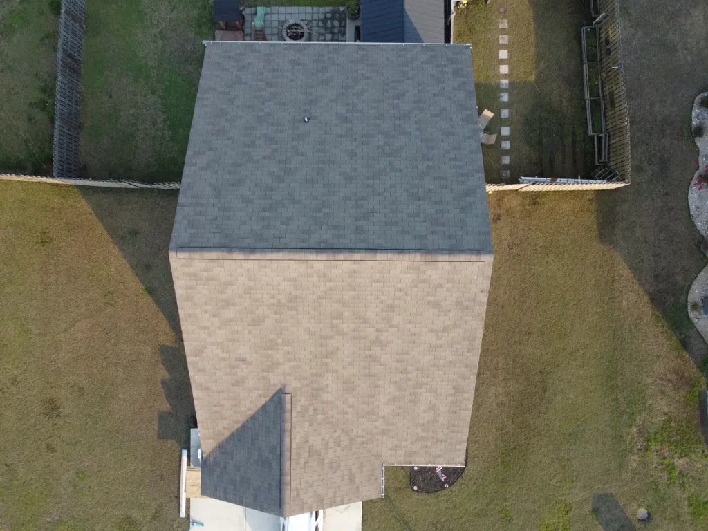 Aerial view of a house with a gray roof and tan siding, taken from directly above