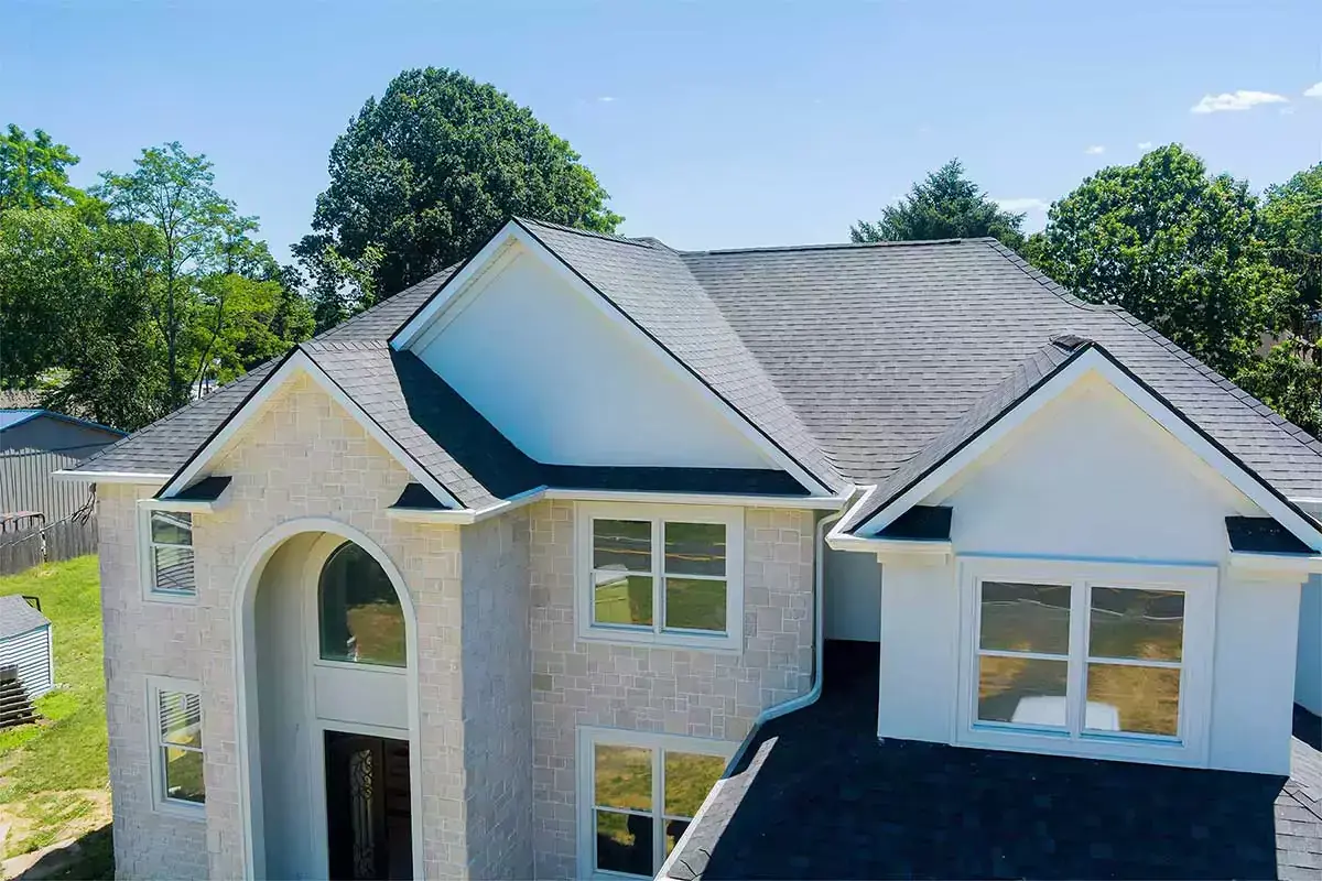 A two-story house with a gray roof and white exterior in a suburban setting